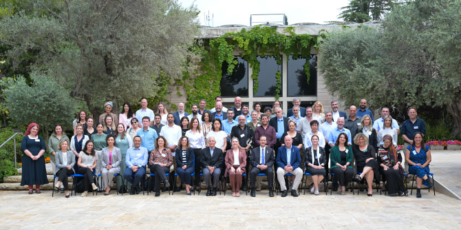 Group photo of some 60 people outside the President's Residence